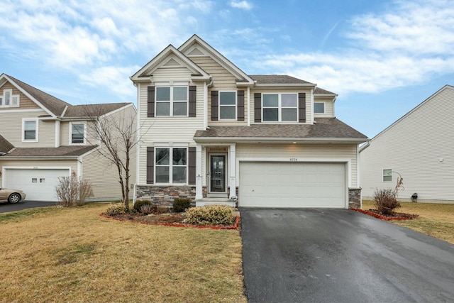 craftsman-style home featuring a garage, stone siding, a front lawn, and driveway