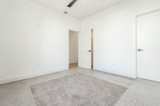 unfurnished room with ceiling fan and baseboards