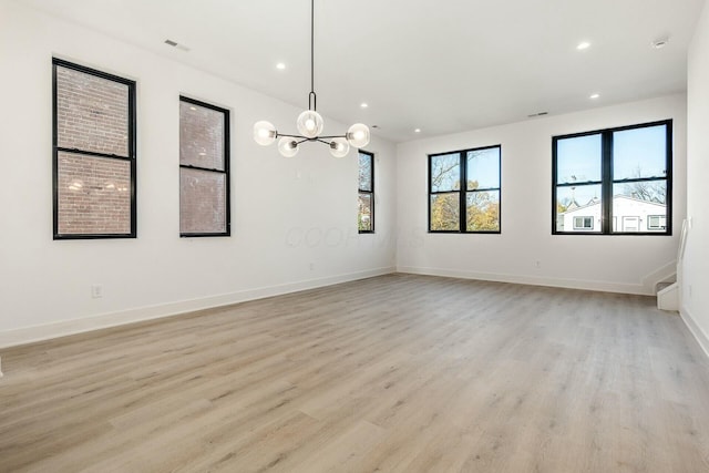 spare room featuring light wood-type flooring, visible vents, baseboards, and recessed lighting