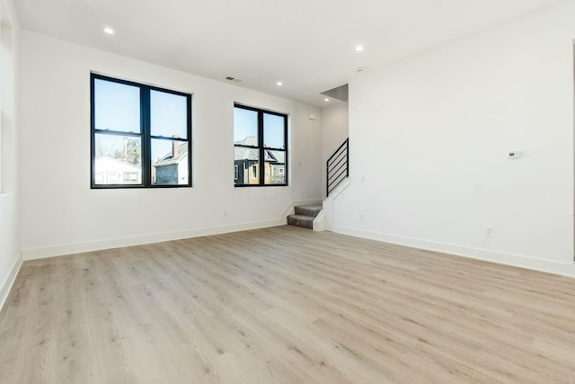 unfurnished room with light wood-style flooring, stairs, baseboards, and recessed lighting