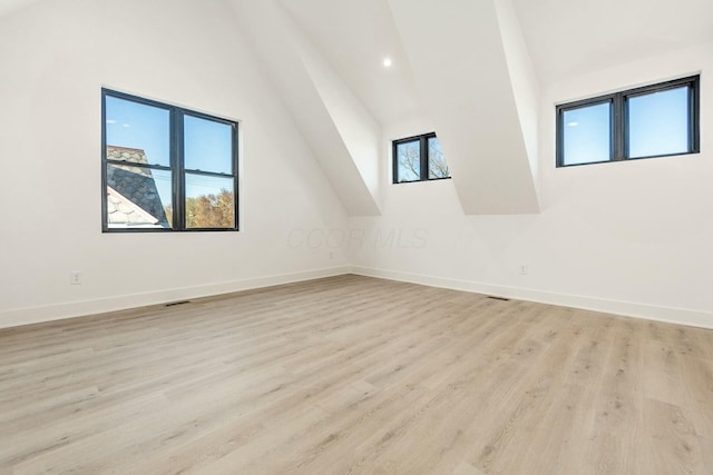 bonus room with high vaulted ceiling, light wood-type flooring, visible vents, and baseboards