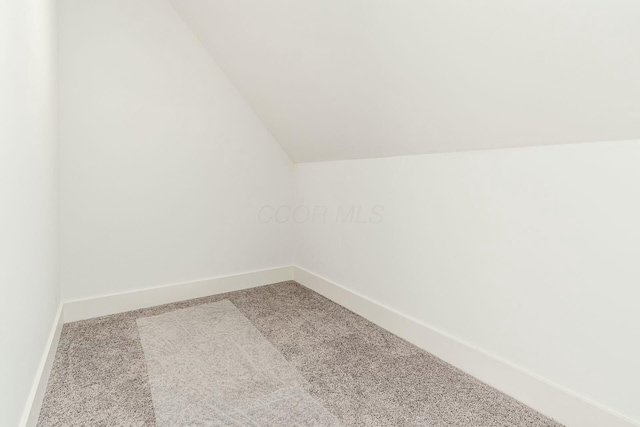 additional living space featuring vaulted ceiling, carpet floors, and baseboards