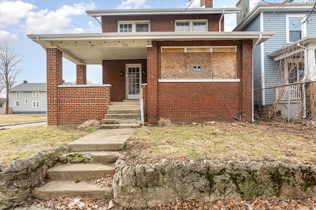 view of front of house featuring brick siding, a chimney, and a porch