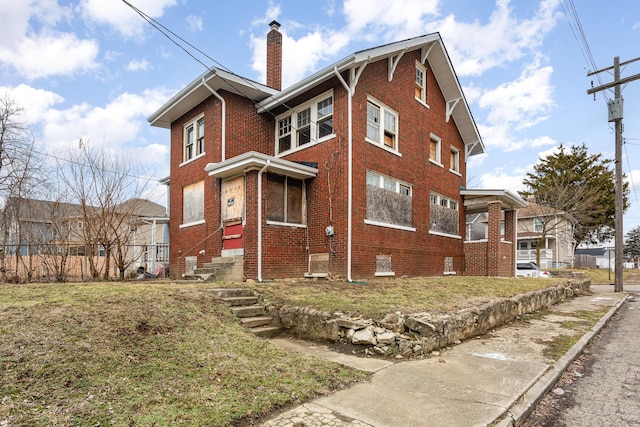 exterior space featuring a yard, a chimney, and brick siding