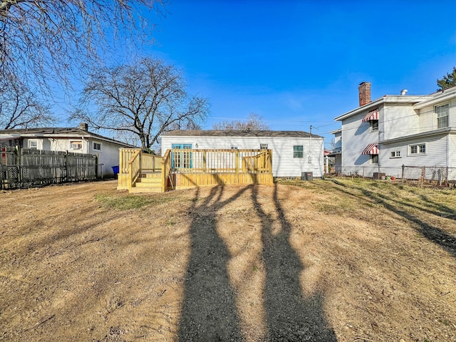 rear view of house with central air condition unit, a deck, and fence