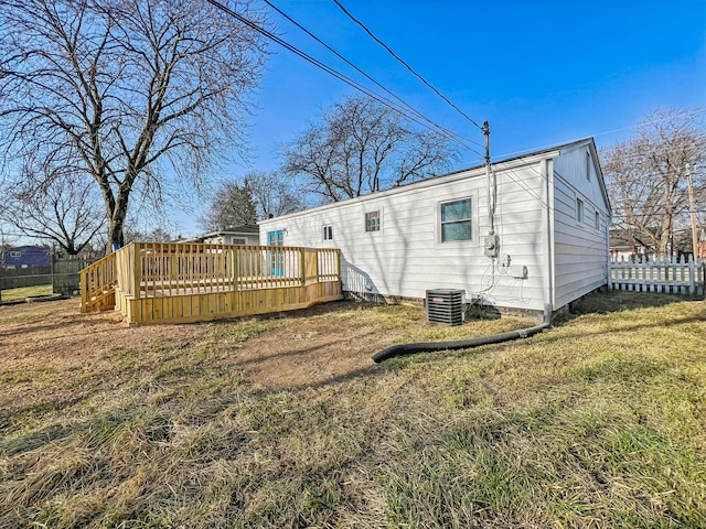 back of property with a lawn, a deck, and fence