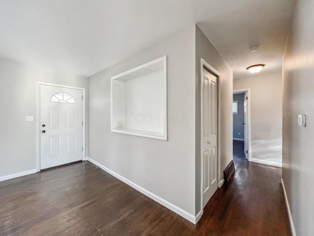 foyer featuring baseboards and wood finished floors