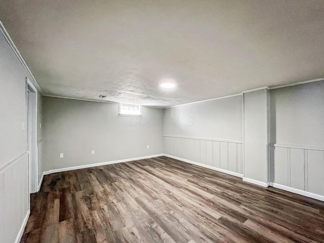 below grade area with wood finished floors and ornamental molding