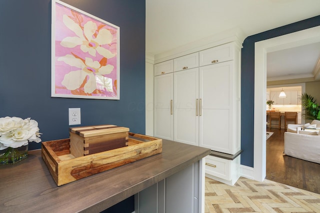 interior space featuring ornamental molding, light wood-style flooring, and baseboards