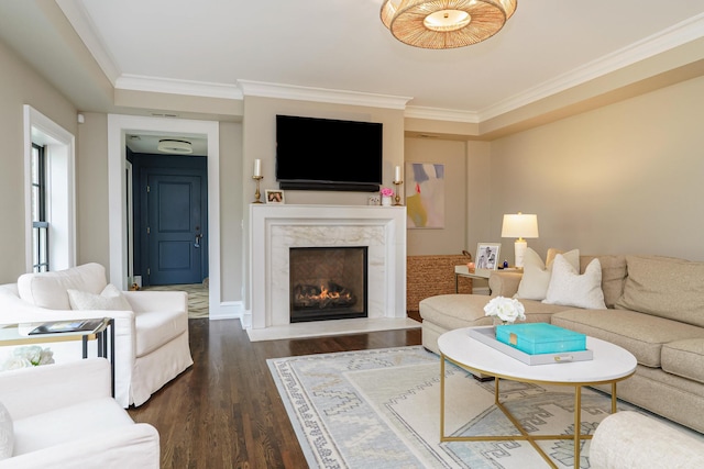 living room with a premium fireplace, ornamental molding, and dark wood finished floors