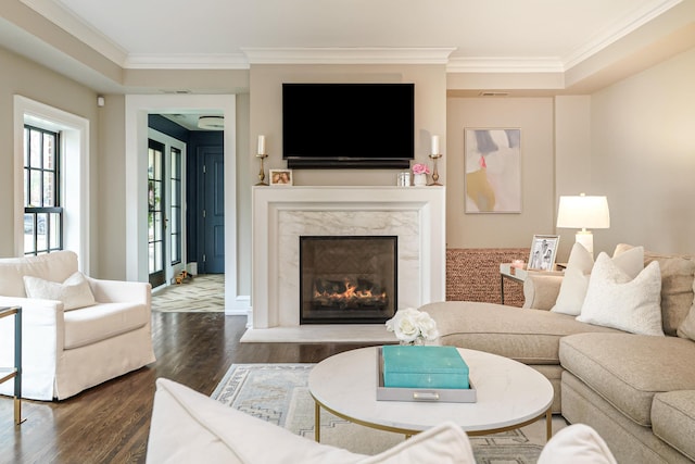 living room featuring crown molding, a fireplace, and wood finished floors