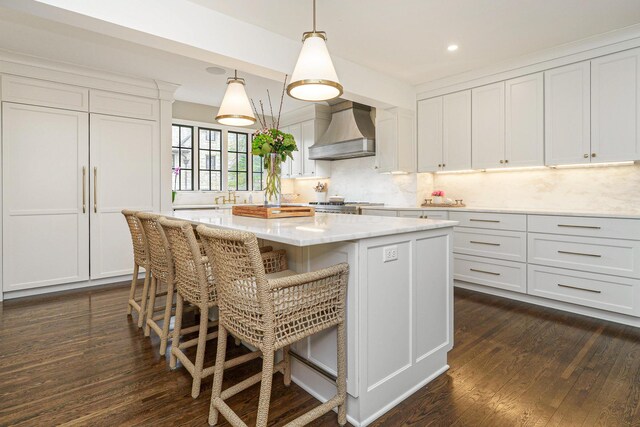 kitchen with dark wood-type flooring, a breakfast bar, backsplash, custom exhaust hood, and a center island