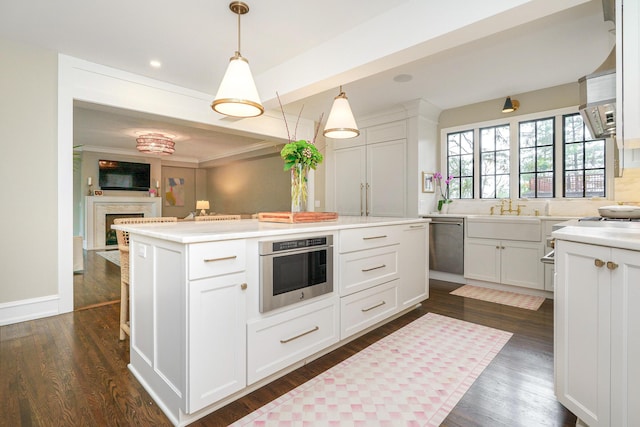 kitchen featuring white cabinets, a kitchen island, appliances with stainless steel finishes, and dark wood finished floors