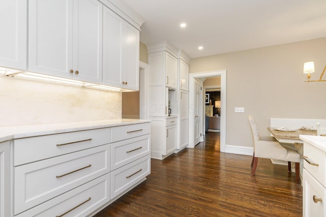 kitchen with recessed lighting, dark wood-type flooring, baseboards, white cabinets, and light countertops