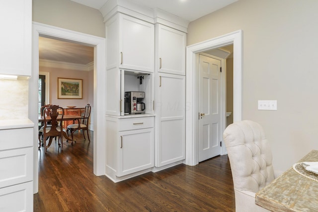 kitchen with ornamental molding, light countertops, dark wood-style flooring, and white cabinetry