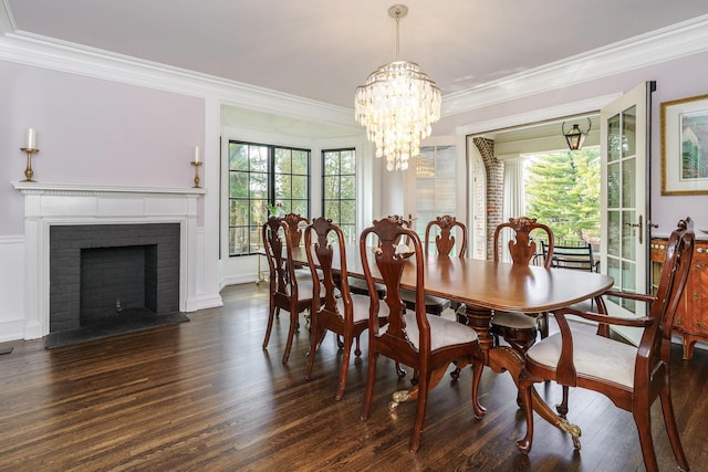 dining space featuring a healthy amount of sunlight, a fireplace, crown molding, and wood finished floors