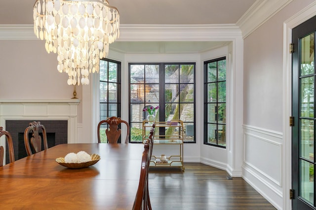 dining room with a decorative wall, ornamental molding, dark wood-style flooring, and an inviting chandelier