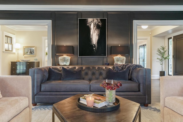 living area featuring baseboards, crown molding, and wood finished floors