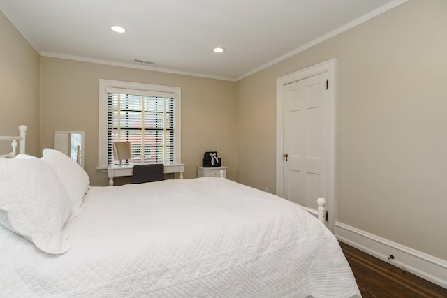 bedroom with baseboards, visible vents, dark wood finished floors, and crown molding