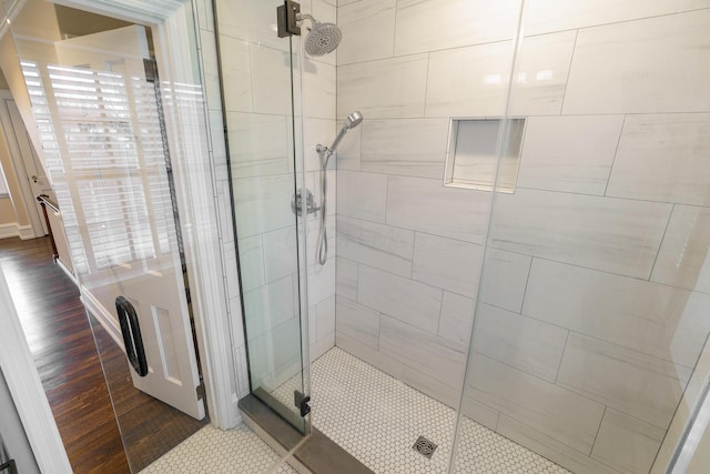 full bathroom featuring a shower stall and wood finished floors