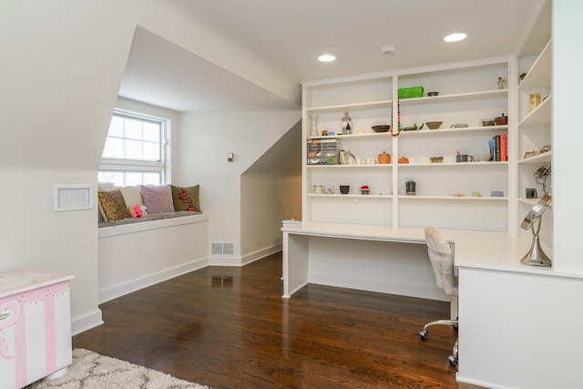 office area with dark wood-style floors, baseboards, visible vents, and built in desk