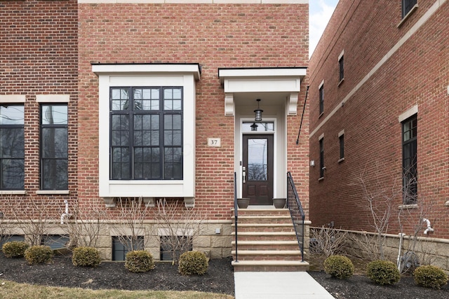 property entrance with fence and brick siding