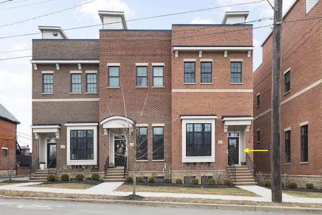 view of property featuring entry steps and brick siding