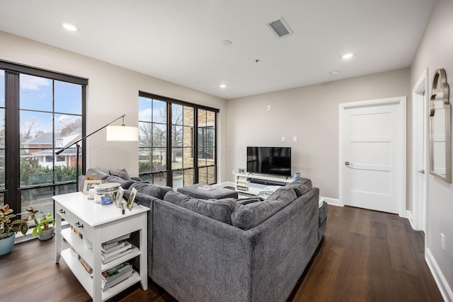 living area with dark wood-style floors, recessed lighting, visible vents, and baseboards