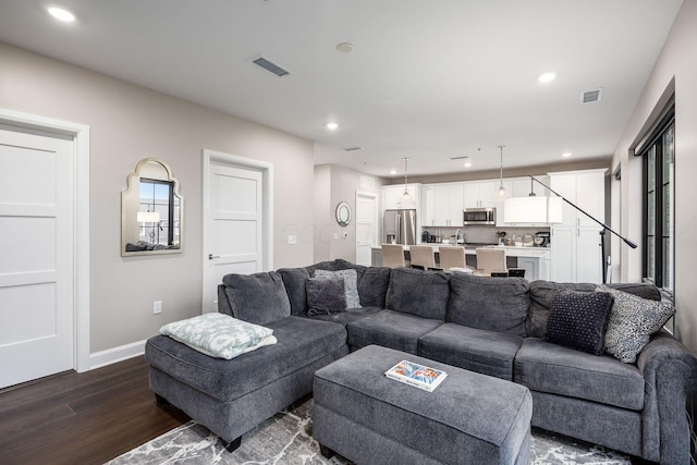 living room with recessed lighting, dark wood-style flooring, visible vents, and baseboards