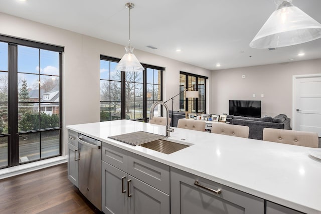 kitchen with a sink, dark wood-style flooring, dishwasher, and gray cabinetry