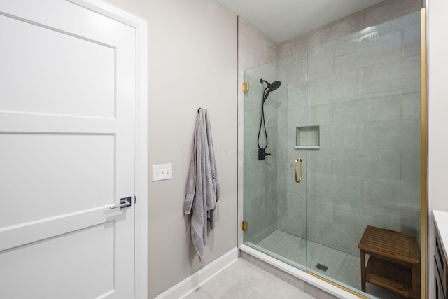 full bath with a stall shower, tile patterned flooring, baseboards, and vanity