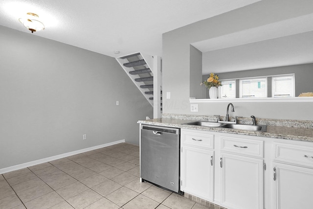 kitchen featuring light tile patterned floors, a sink, white cabinets, light countertops, and stainless steel dishwasher