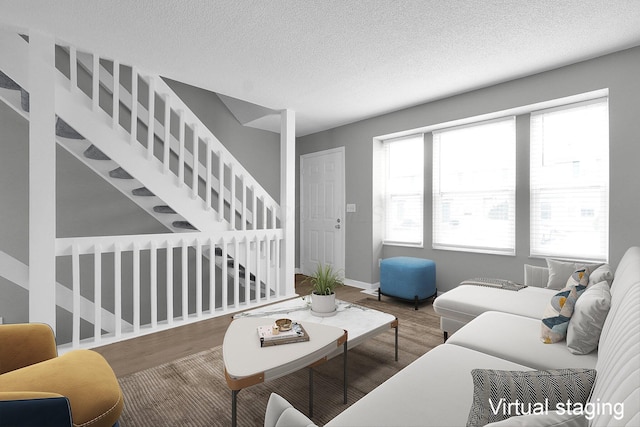 living room featuring baseboards, stairway, a textured ceiling, and wood finished floors