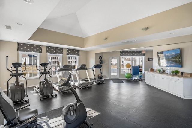 gym with visible vents, vaulted ceiling, and baseboards