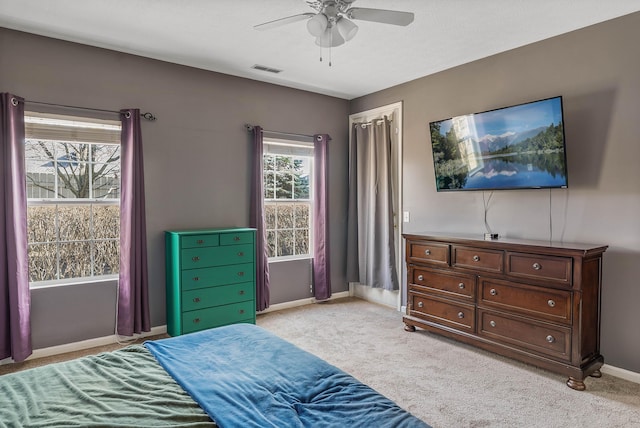 bedroom featuring a ceiling fan, light carpet, visible vents, and baseboards