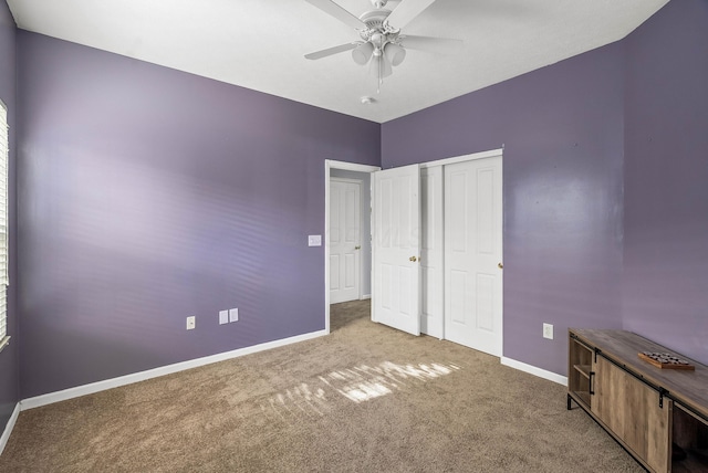 unfurnished bedroom with carpet floors, a closet, ceiling fan, and baseboards