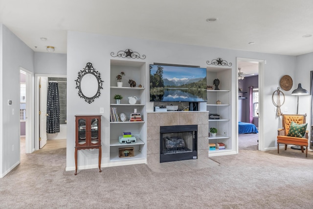 living room with a healthy amount of sunlight, carpet flooring, and a tile fireplace