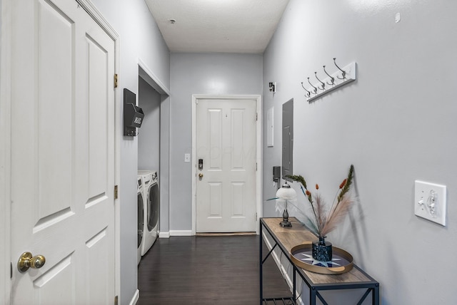 entryway with a textured ceiling, washing machine and dryer, dark wood finished floors, and baseboards