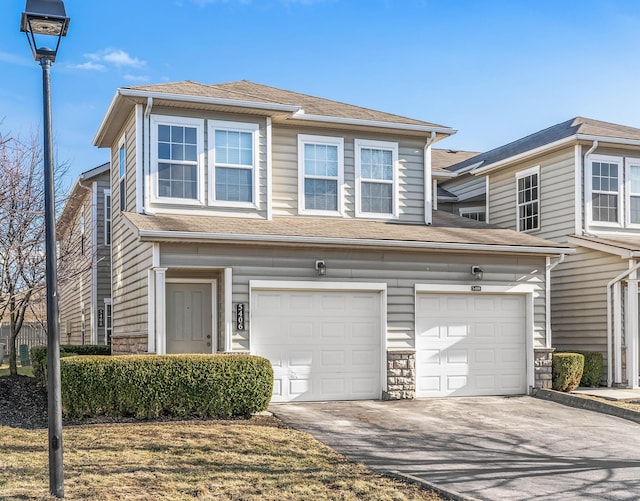 view of front of property with a garage, stone siding, a shingled roof, and concrete driveway