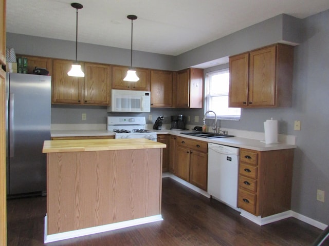 kitchen with white appliances, a sink, wood counters, a center island, and dark wood finished floors