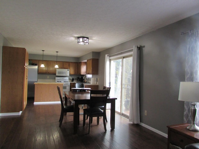 dining room featuring dark wood finished floors, a textured ceiling, and baseboards