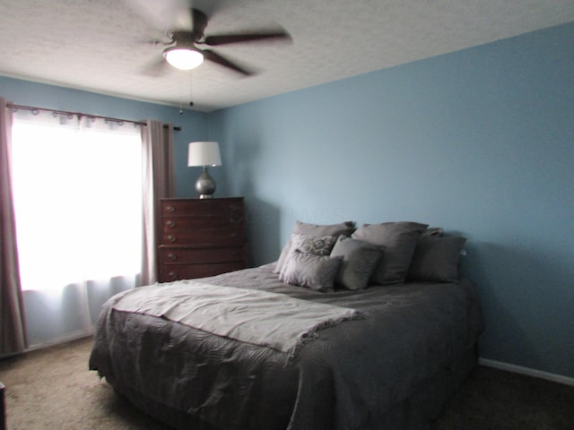 bedroom featuring a textured ceiling, carpet flooring, a ceiling fan, and baseboards