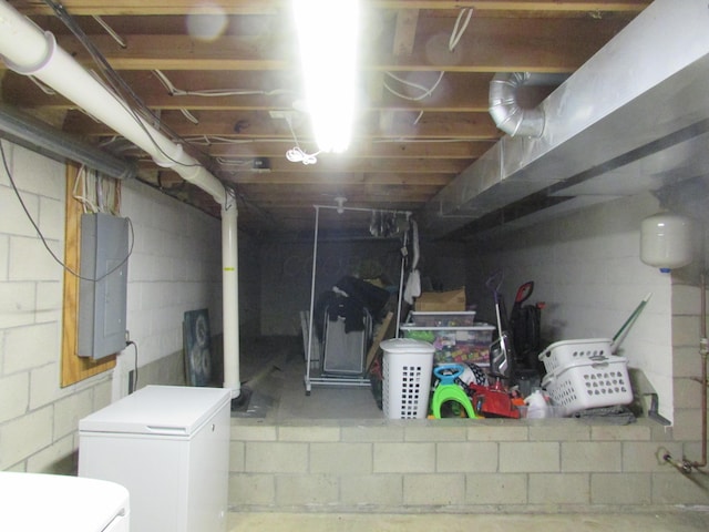 unfinished basement featuring washer / dryer, electric panel, and fridge