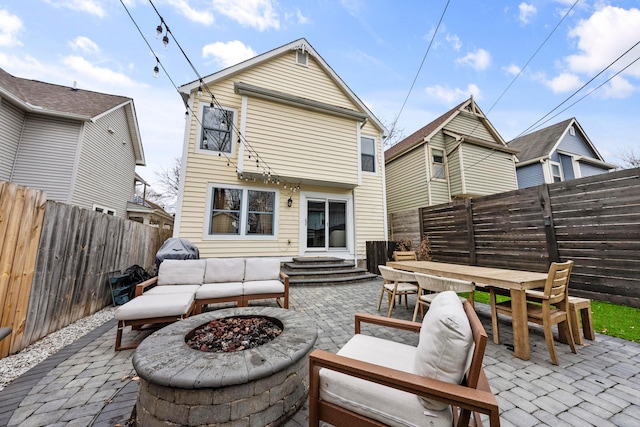 back of house featuring entry steps, a patio, outdoor dining area, and a fenced backyard