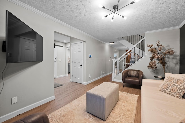 living area featuring wood finished floors, visible vents, stairway, and a barn door