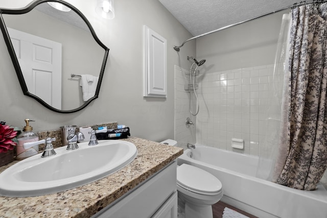 full bathroom featuring a textured ceiling, vanity, toilet, and shower / tub combo with curtain