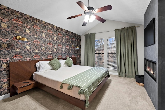 bedroom with a large fireplace, carpet flooring, a ceiling fan, vaulted ceiling, and wallpapered walls