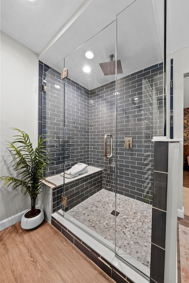 full bathroom featuring a stall shower, wood finished floors, and baseboards