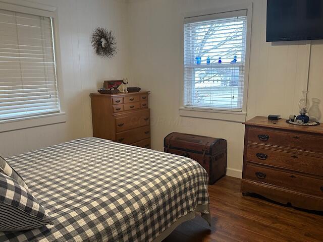 bedroom with dark wood-style flooring