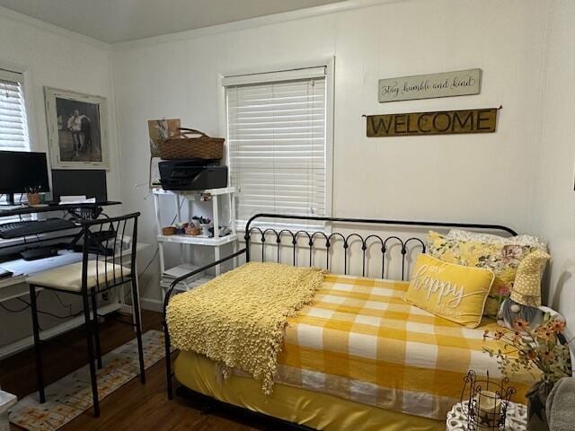 bedroom with crown molding and wood finished floors